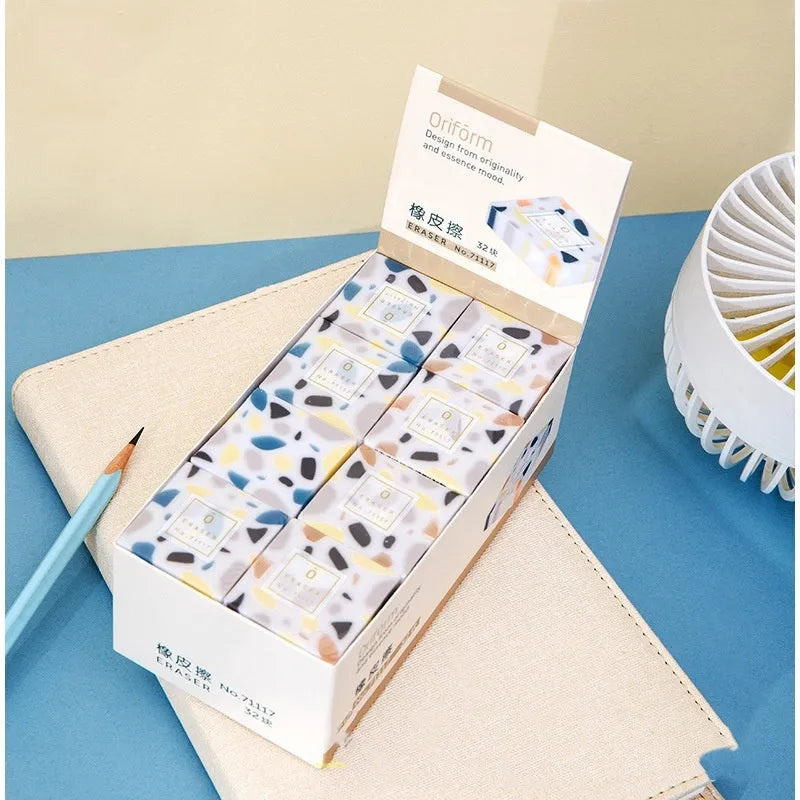 A single white rubber eraser in a brick shape with straight edges, for cleaning pencil marks from paper.