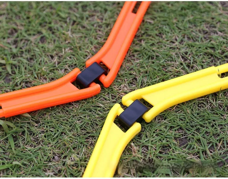 Set of six brightly coloured foldable hexagon football agility training rings on grass