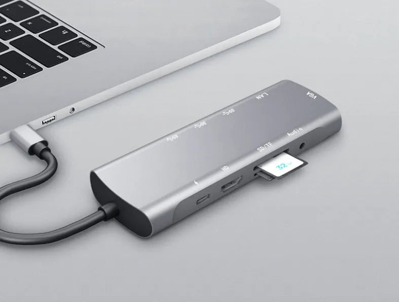 Grey aluminium USB-C docking station showing HDMI, VGA, USB 3.0, and USB-C PD charging ports.