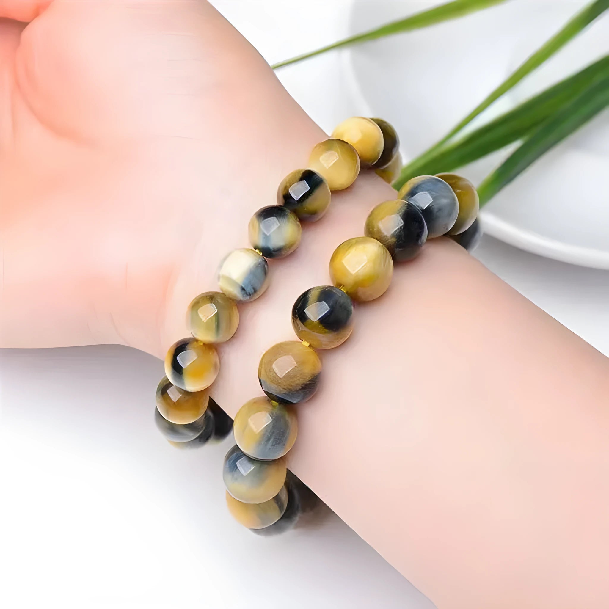 Fantasy Tiger Eye agate bracelet with round beads on a wrist, showing 10mm bead size.