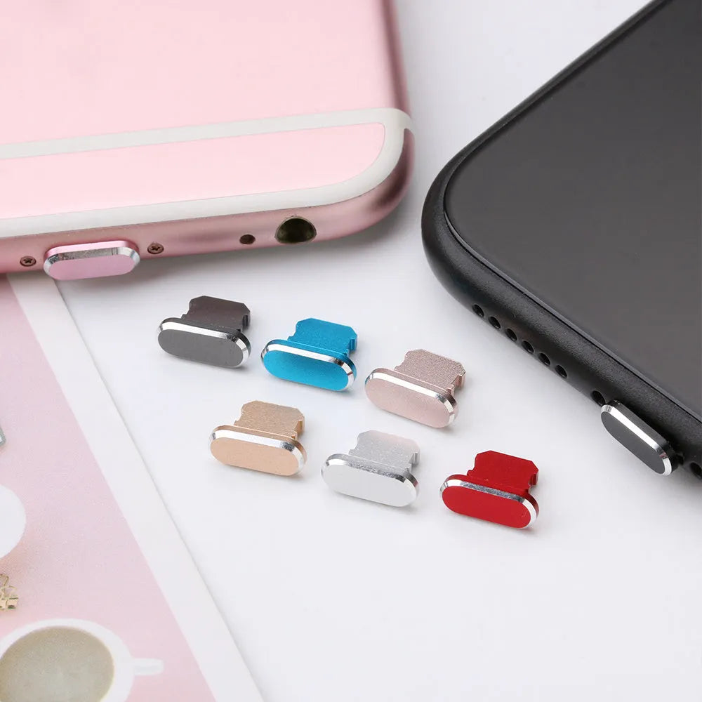 Aluminium alloy iPhone charging port dust plug in metallic colours on a dark background.