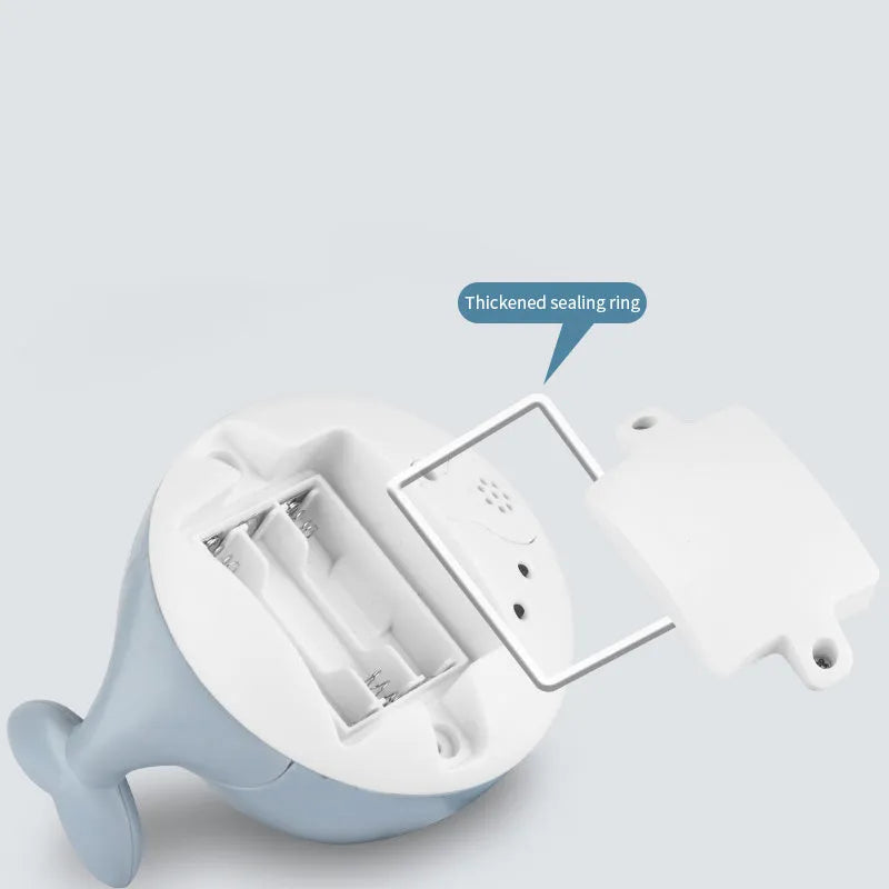 White and blue whale-shaped electric bath toy spraying water with coloured lights flashing