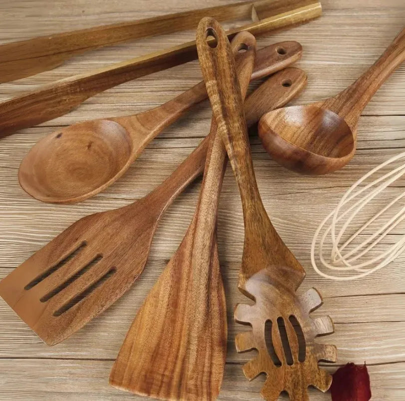 Set of 7 wooden cooking utensils including spoons and shovels arranged on a kitchen surface