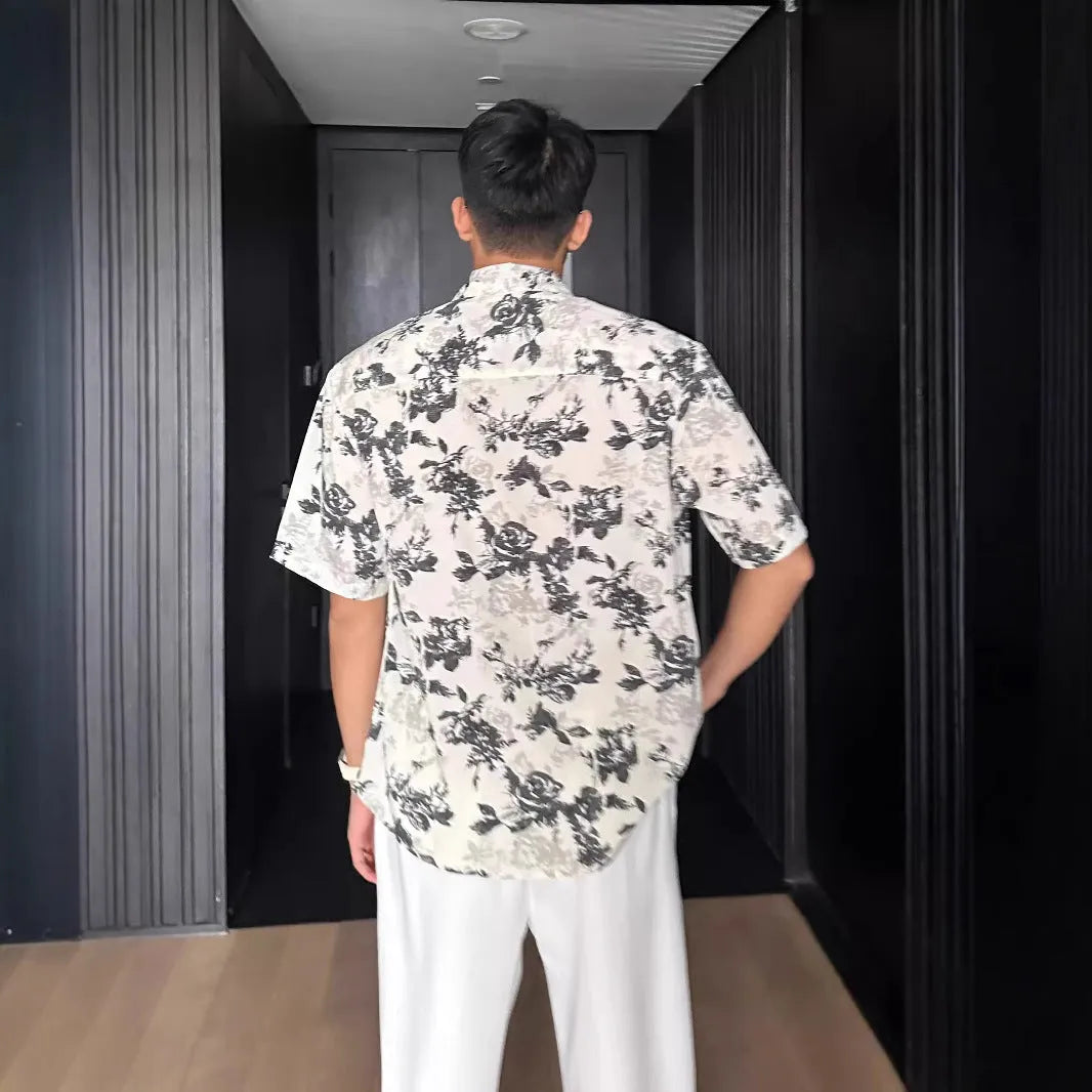 Men's loose black floral print short sleeve casual shirt on a hanger