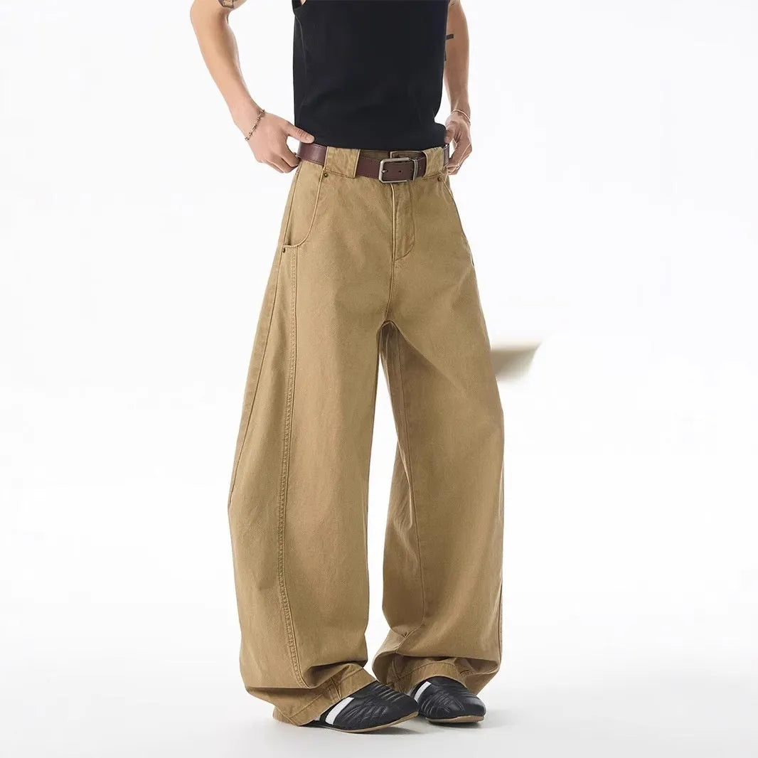 Man wearing brown loose-fit straight leg jeans with a mid waist and button fly.