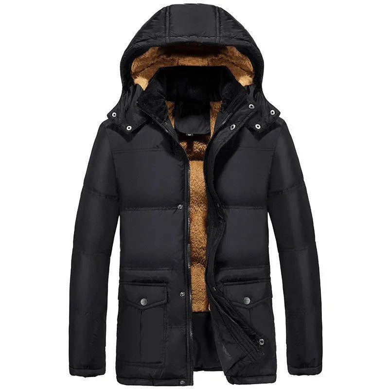 Man wearing a loose-fit black velvet padded jacket with a hood and double-breasted front.