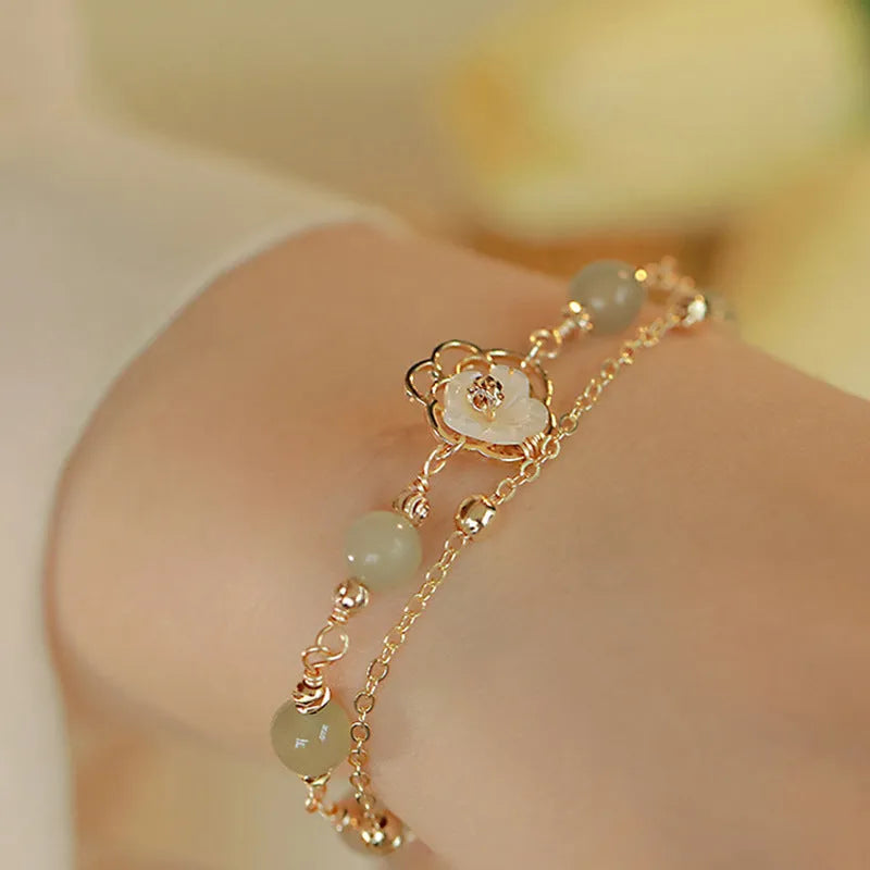 Electroplated copper butterfly bracelet with geometric design and yellow gold finish, showing floral shell motif