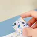 A single white rubber eraser in a brick shape with straight edges, for cleaning pencil marks from paper.