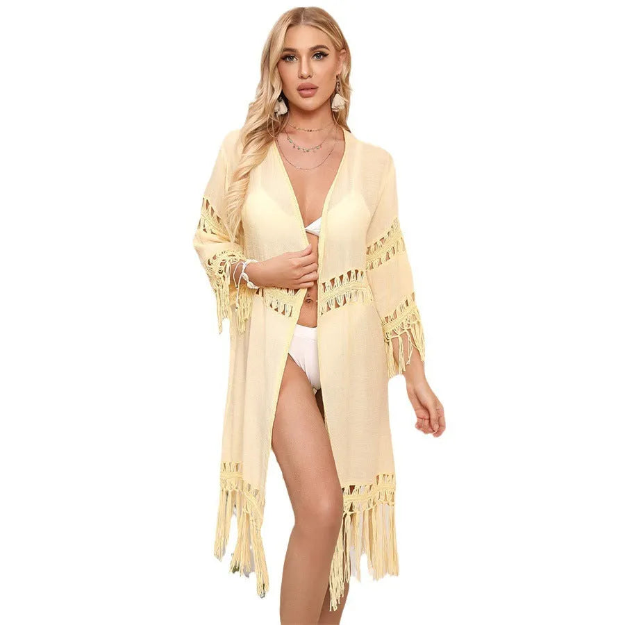 Yellow hand-crocheted acrylic beach cover-up cardigan with tassels on a mannequin