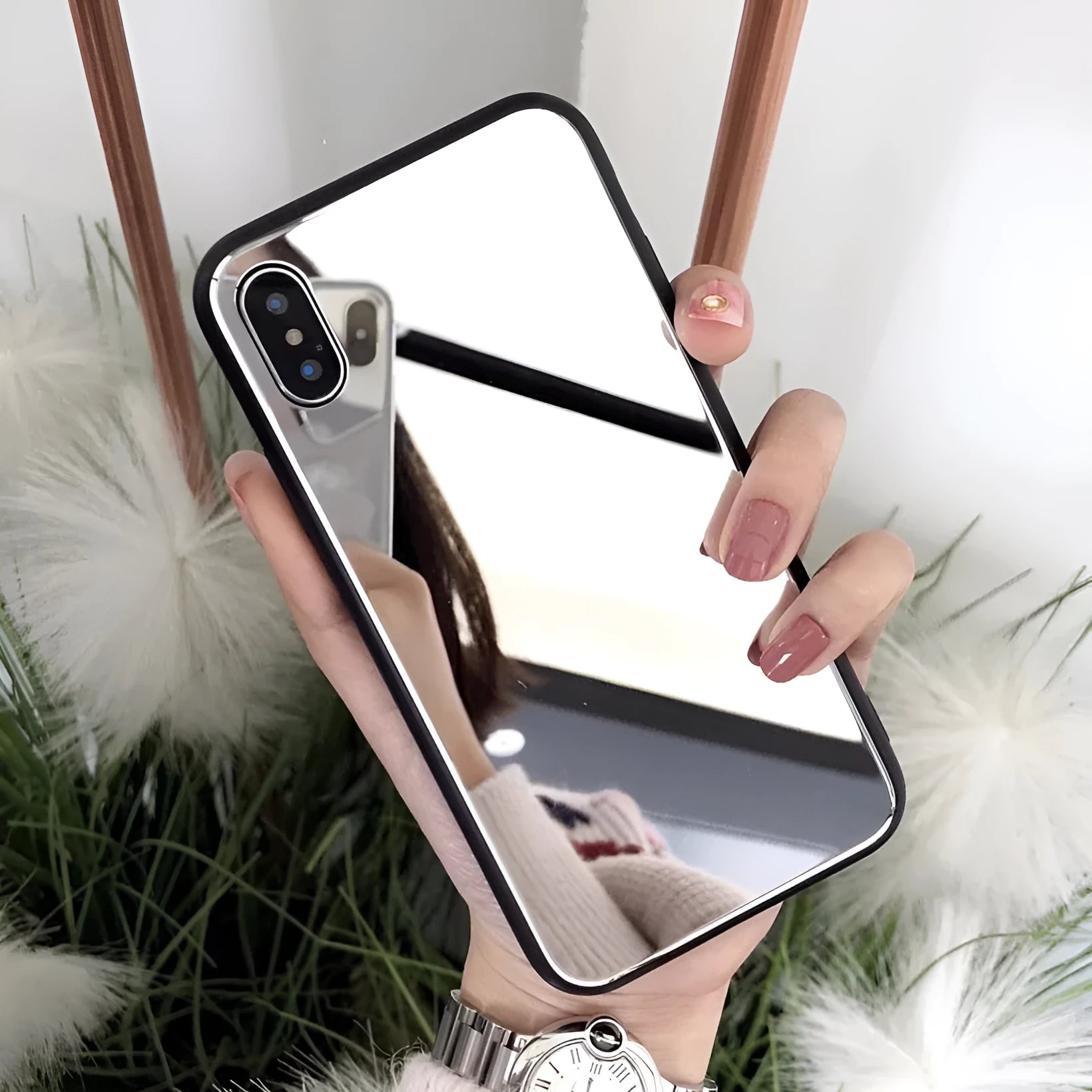 Black iPhone case with a mirrored back panel, shown next to an iPhone.