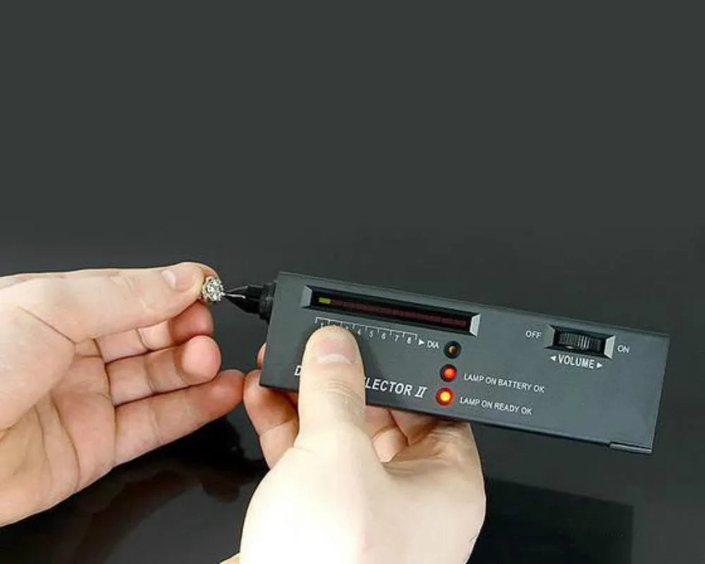 Black second generation diamond thermal conductivity tester with metal probe, shown with scale.