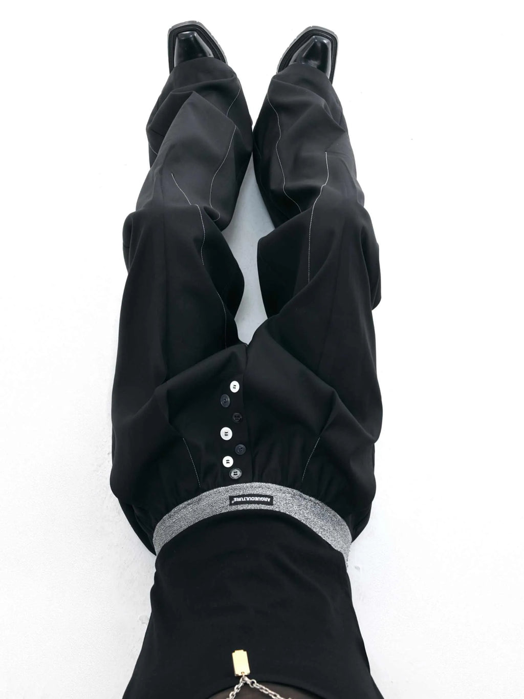 High-waisted drooping straight-leg trousers in black with button open line design detail.
