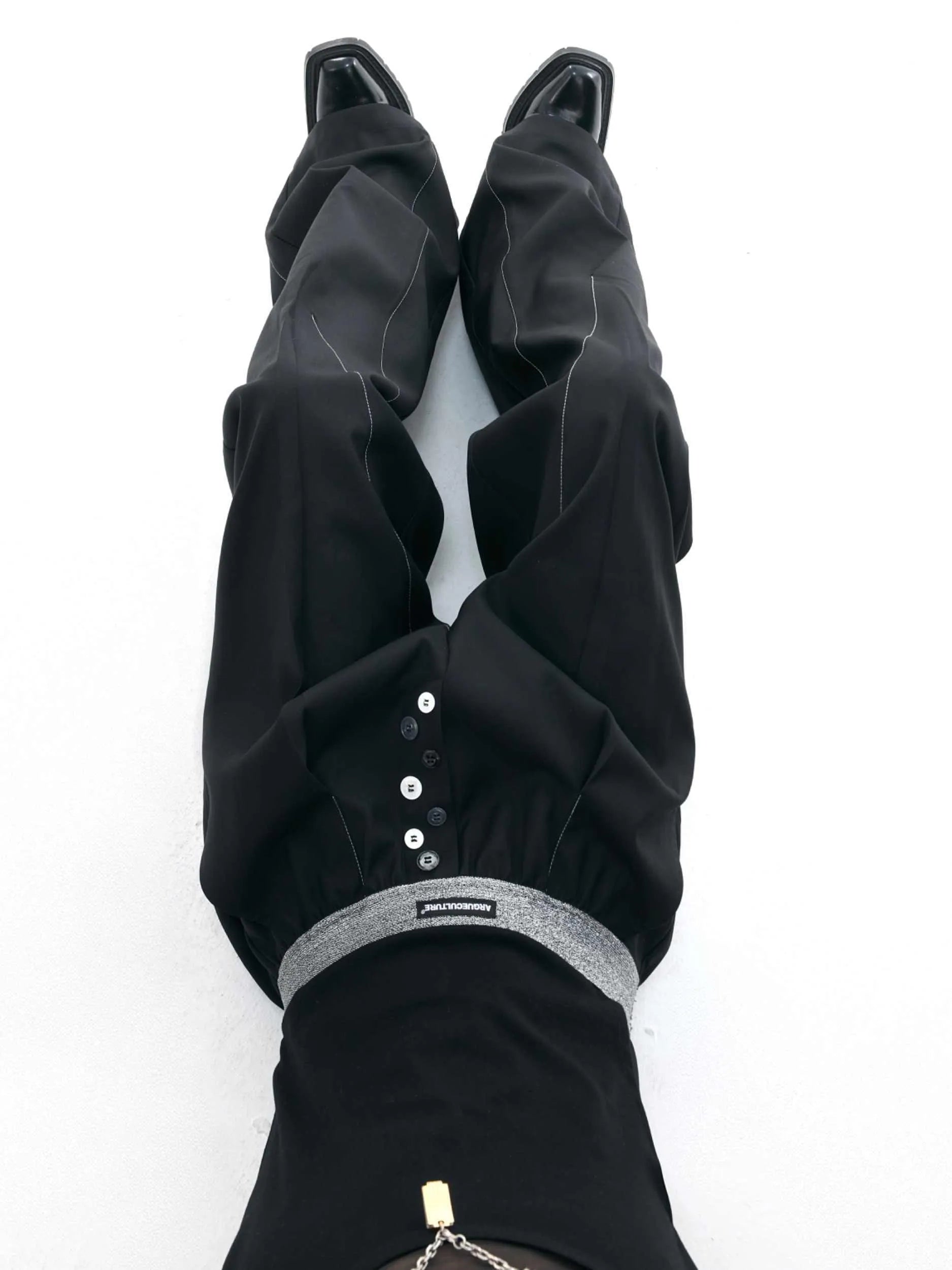 High-waisted drooping straight-leg trousers in black with button open line design detail.