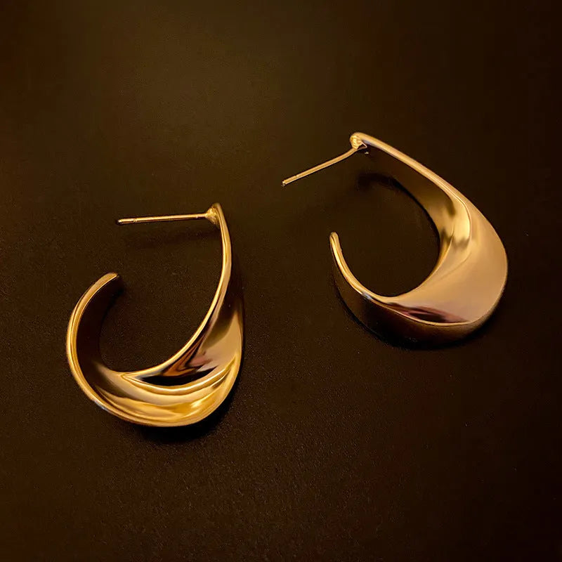 Gold and silver geometric twisted metal earrings with round design elements