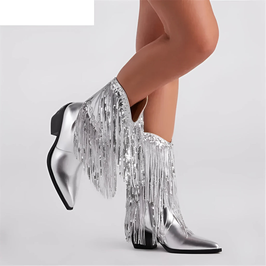 Women's black chunky heel tassel boots with pointed toe and high stiletto heel on a plain background.
