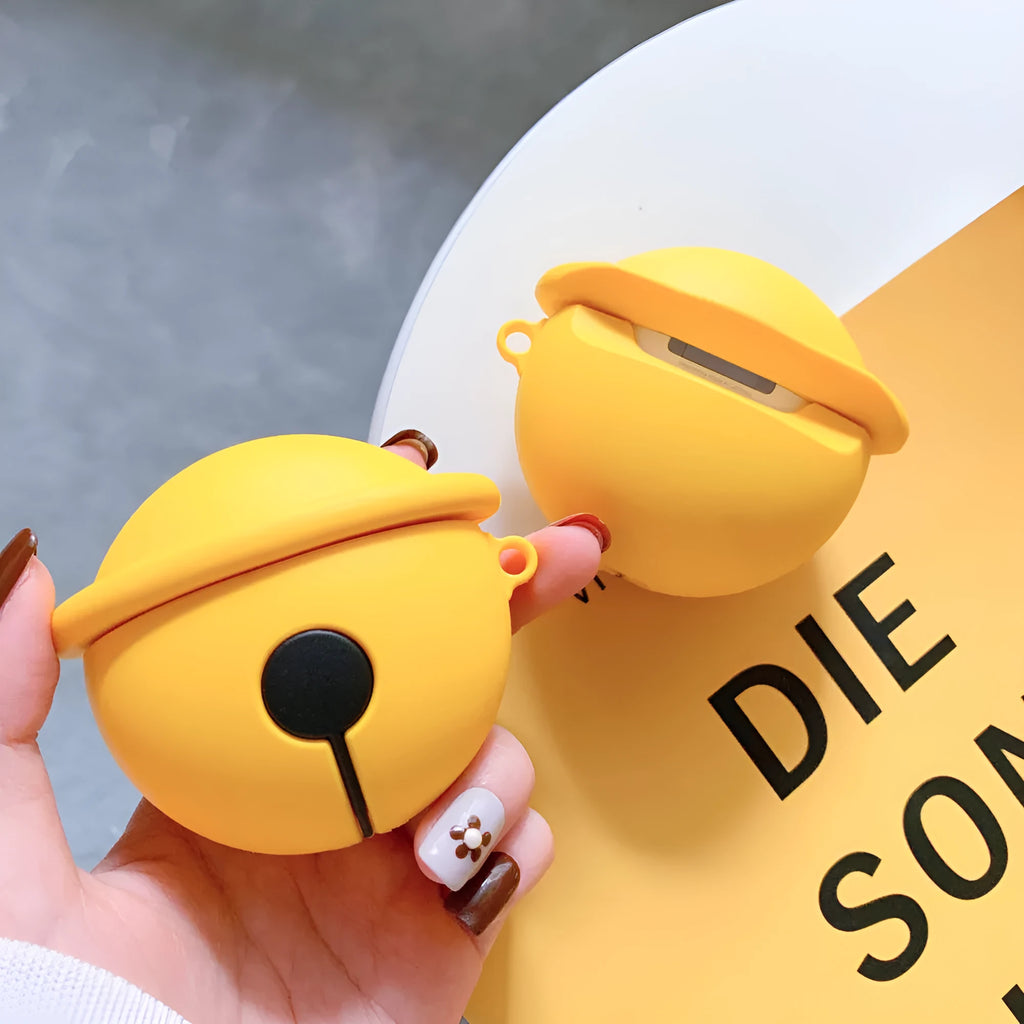 Yellow silicone protective case for AirPods with a small bell charm and a carry strap.