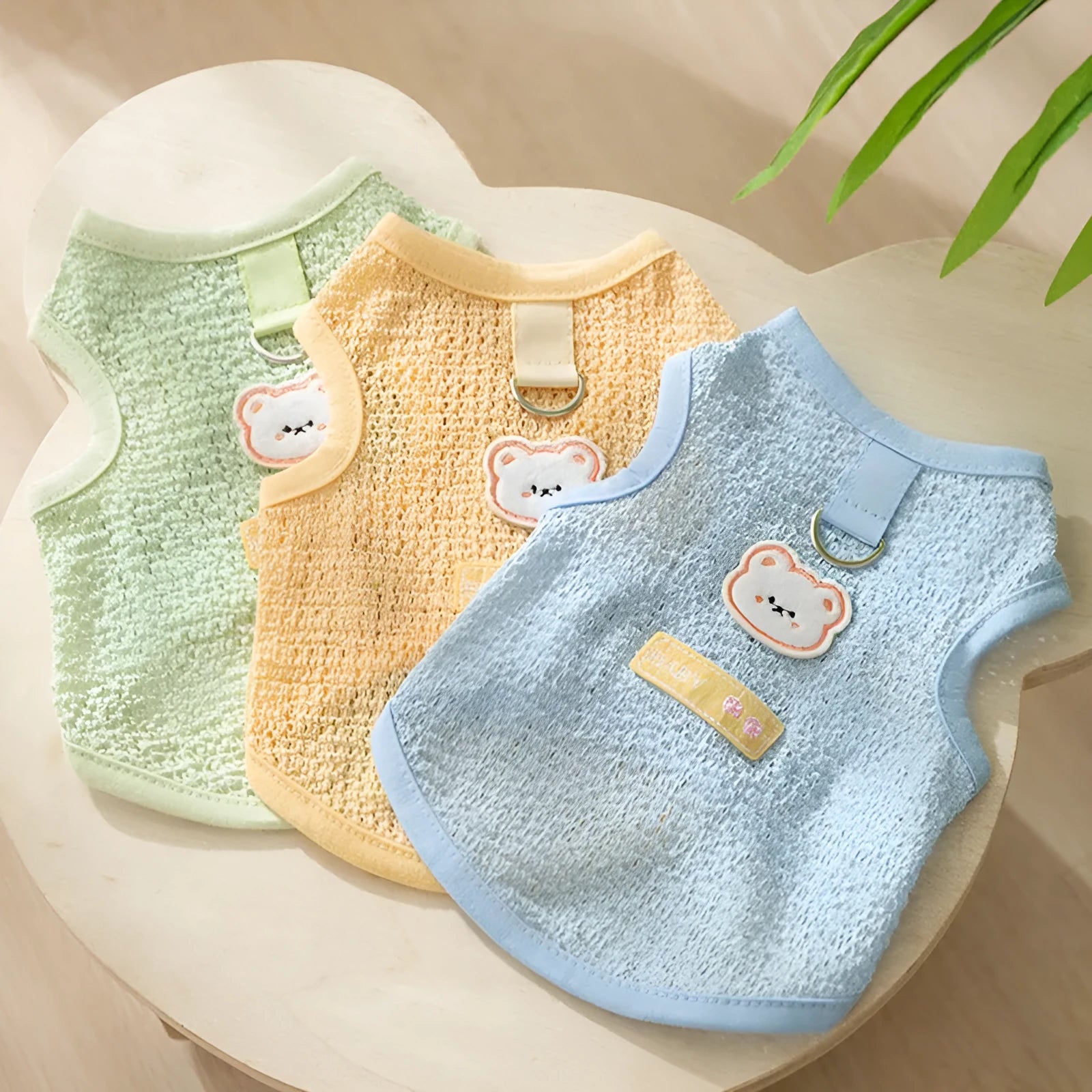 Blue knitted cat clothing with a bear patch, showing hollowed-out breathable design