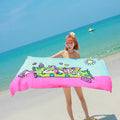 Flower-coloured swimming absorbent microfiber towel 150x70cm on a beach background
