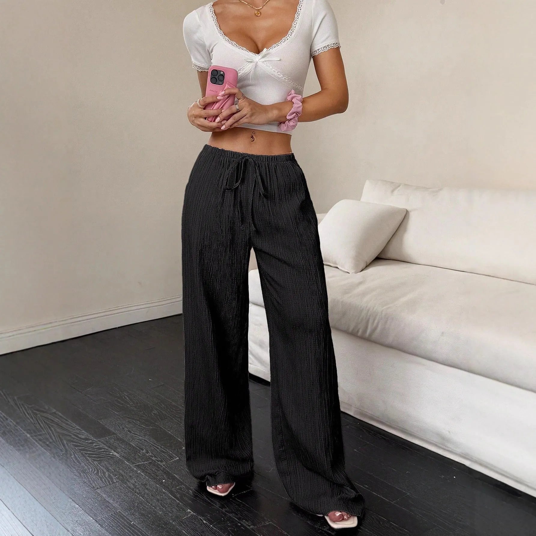 Women's black wide leg trousers with lace-up waist trimming showing adjustable detail