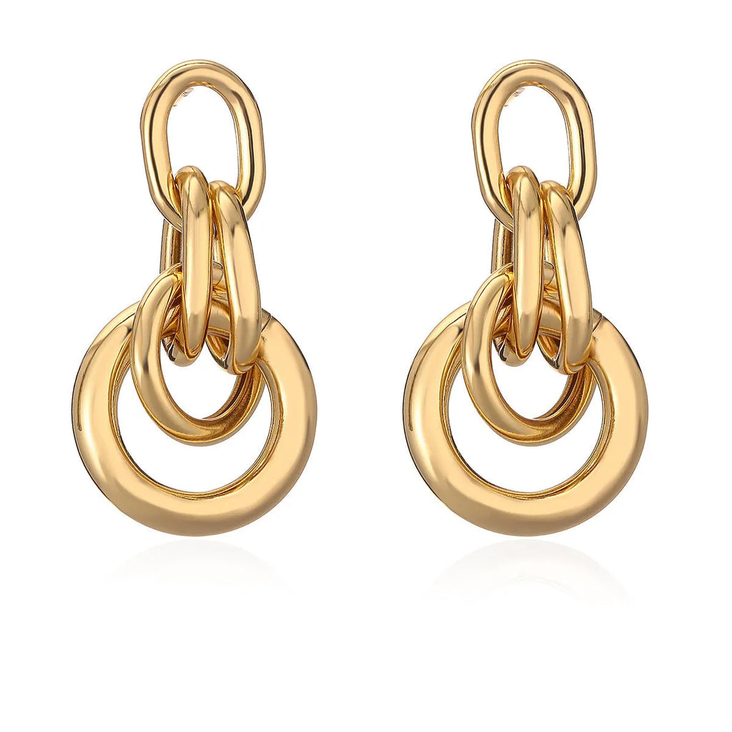 Gold geometric copper earrings with irregular asymmetric design on display