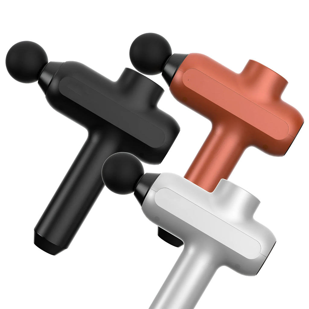 Black electric percussion muscle massager with six different coloured attachment heads on a table.