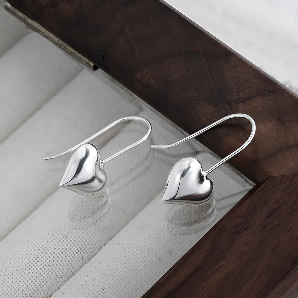 Silver heart shaped earrings with glossy three-dimensional Korean style design