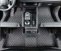 Custom black floor mats installed in a Mitsubishi Outlander footwell.