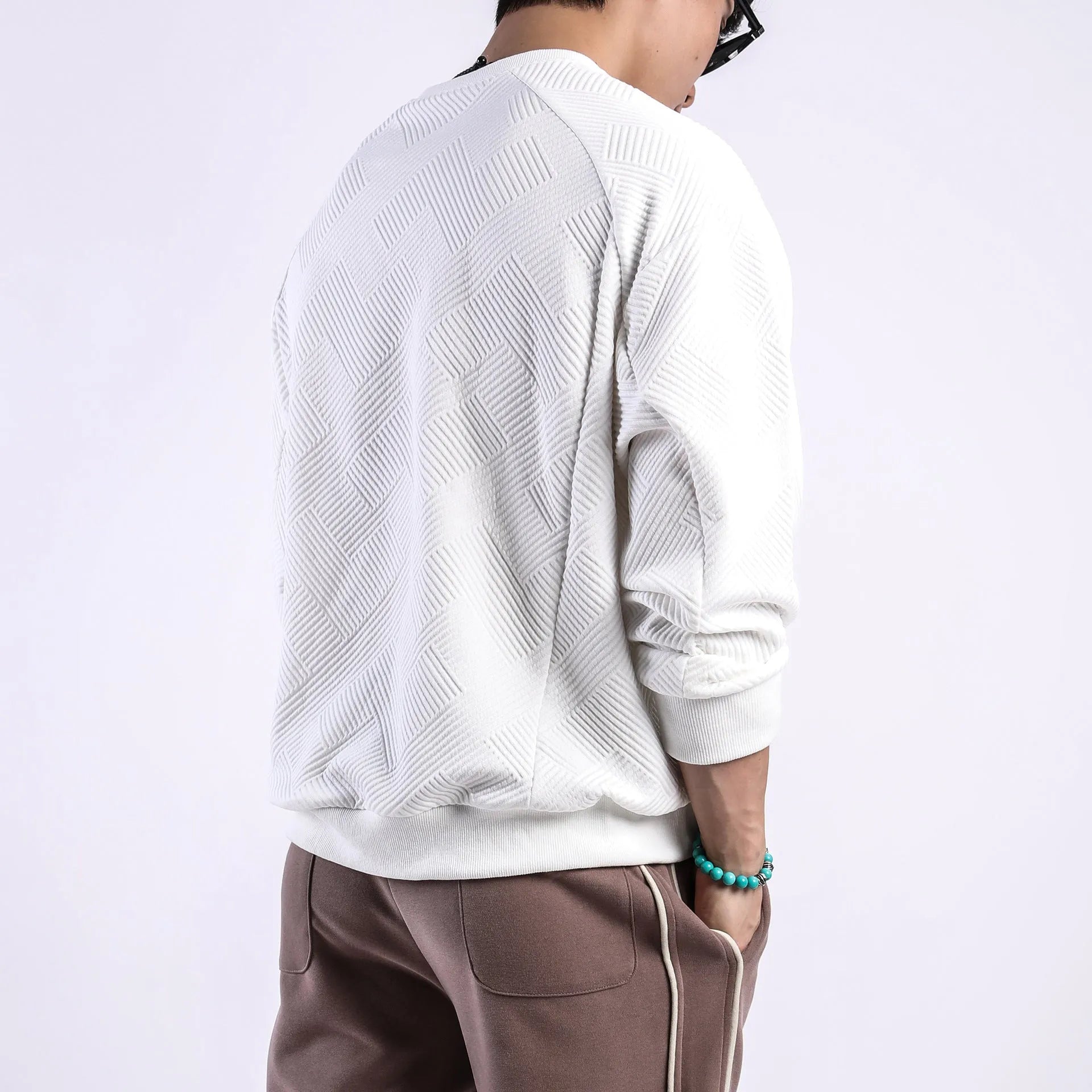 Men's loose fit long sleeve twill Jacquard sweater in solid colours on a hanger.