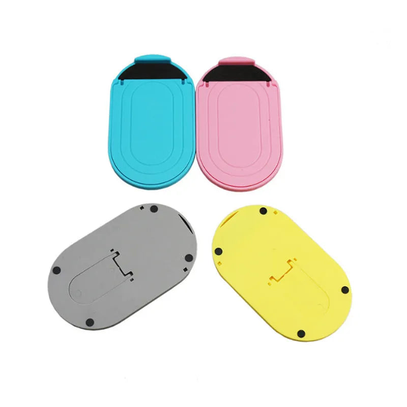 Plastic mobile phone stand with lazy bracket design shown in multiple colour options on a desk