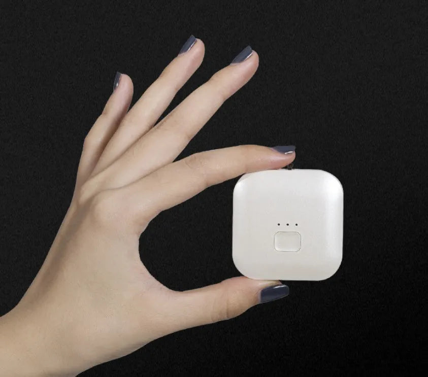 Mini USB portable air purifier necklace in pink, showing compact design with single button.