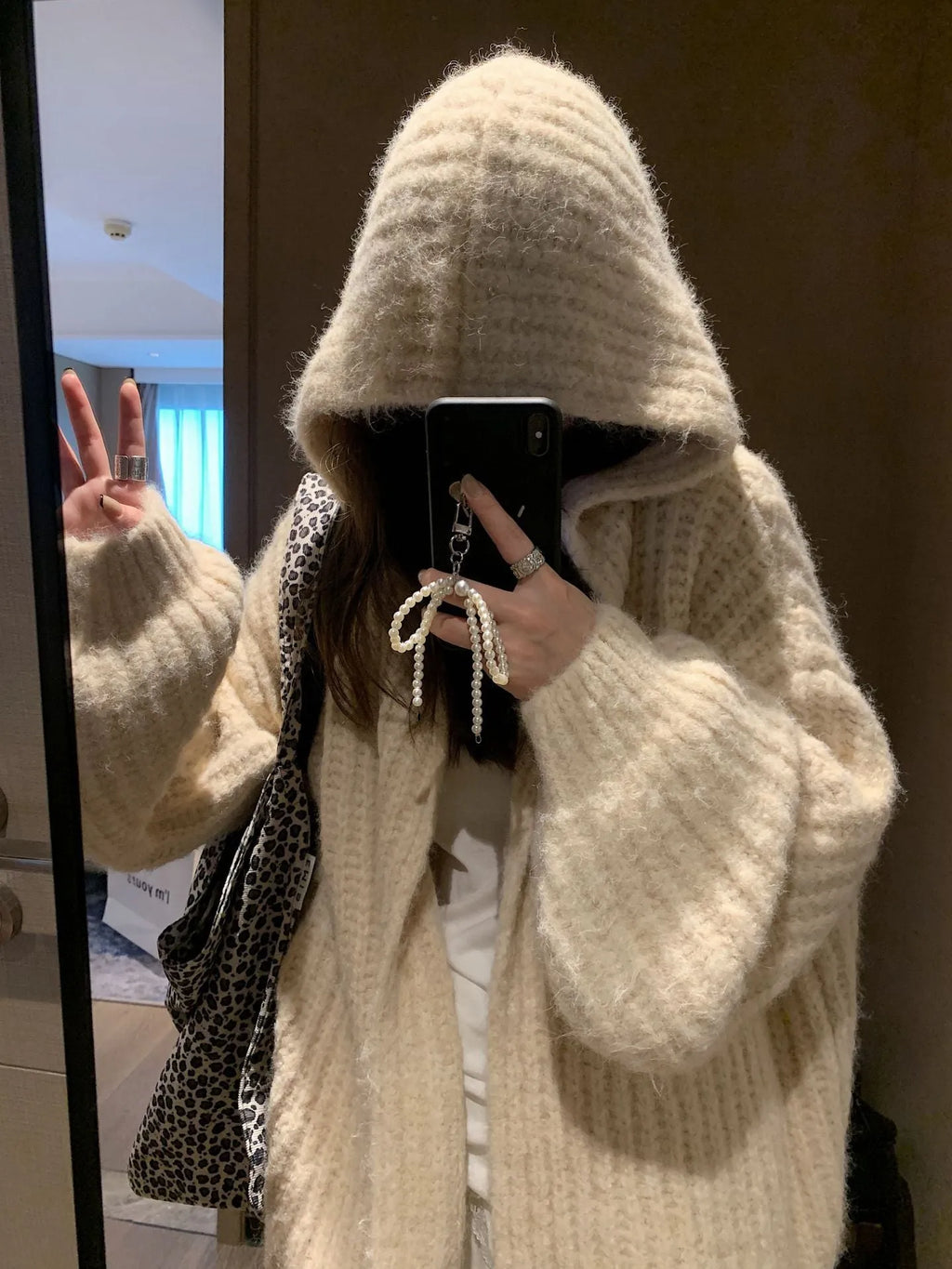 Women's loose-fit hooded cardigan in thick fabric, shown in dark grey, brown, and milky white colours.