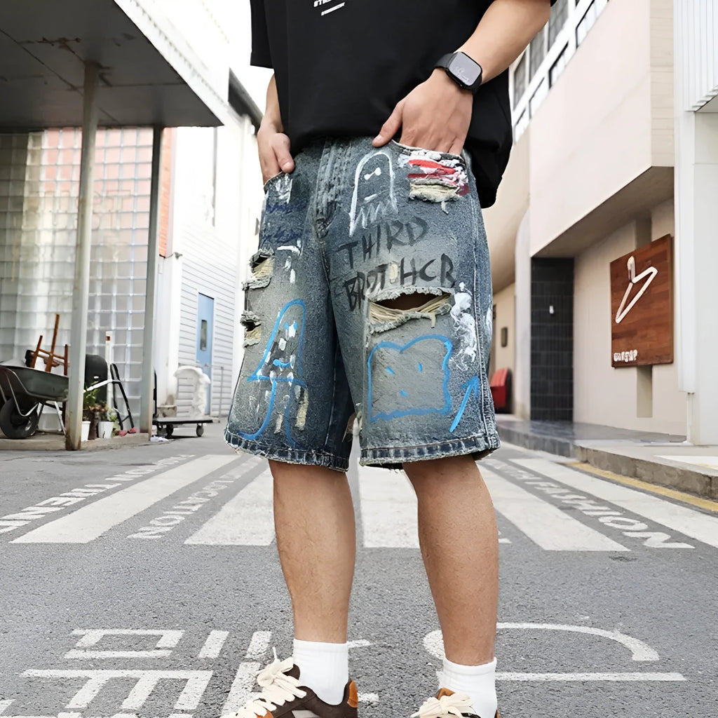 Men's blue ripped jeans shorts with graffiti details and straight leg opening