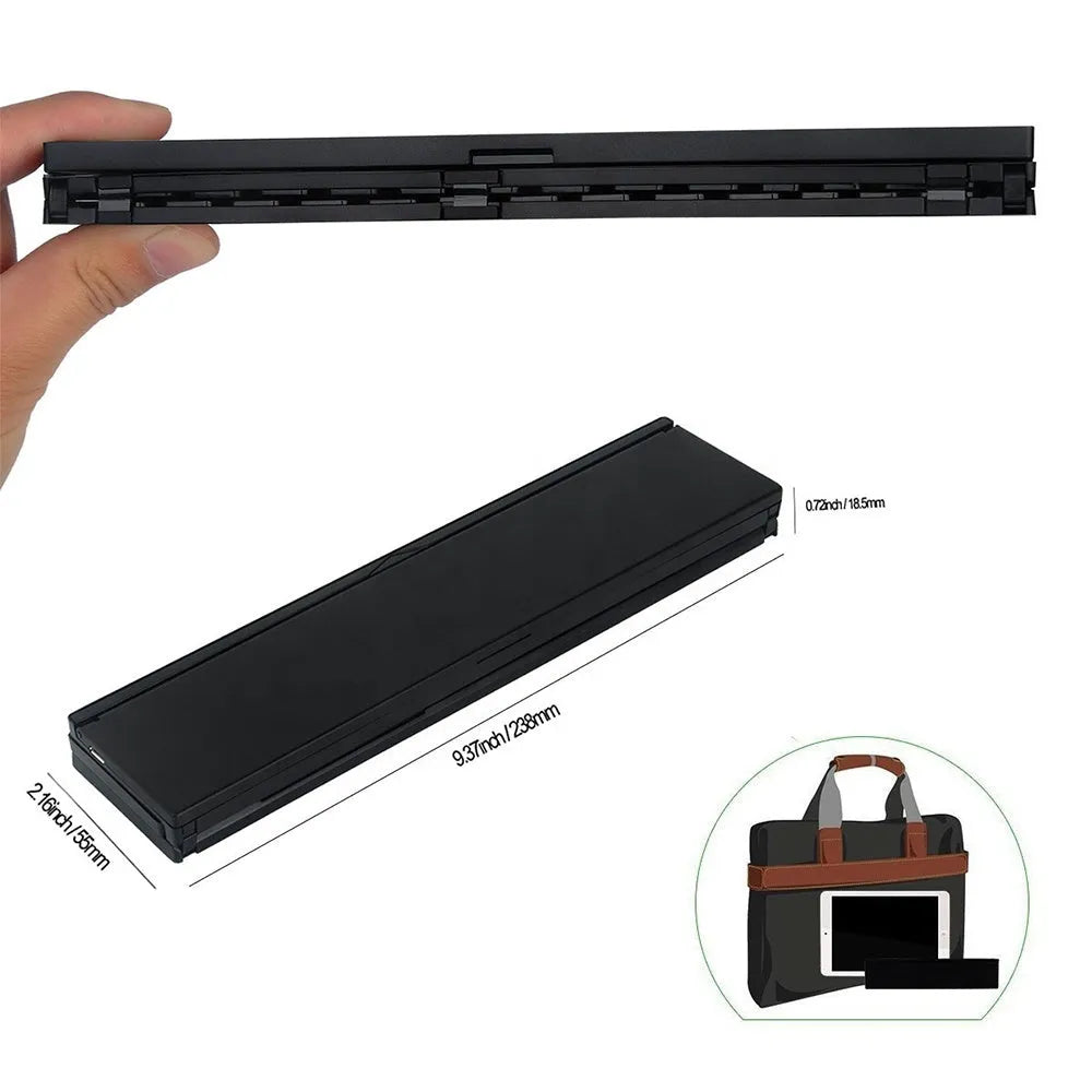 Black folding wireless Bluetooth keyboard shown open next to a tablet demonstrating its compact portable size.