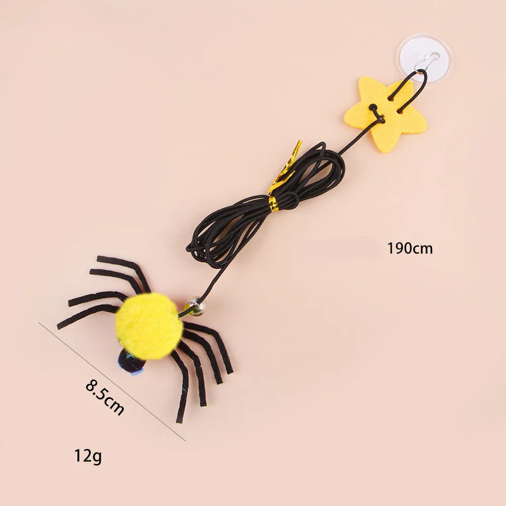 Red and yellow hanging door cat toy with elastic rope, feather, bell, and spider attachments.