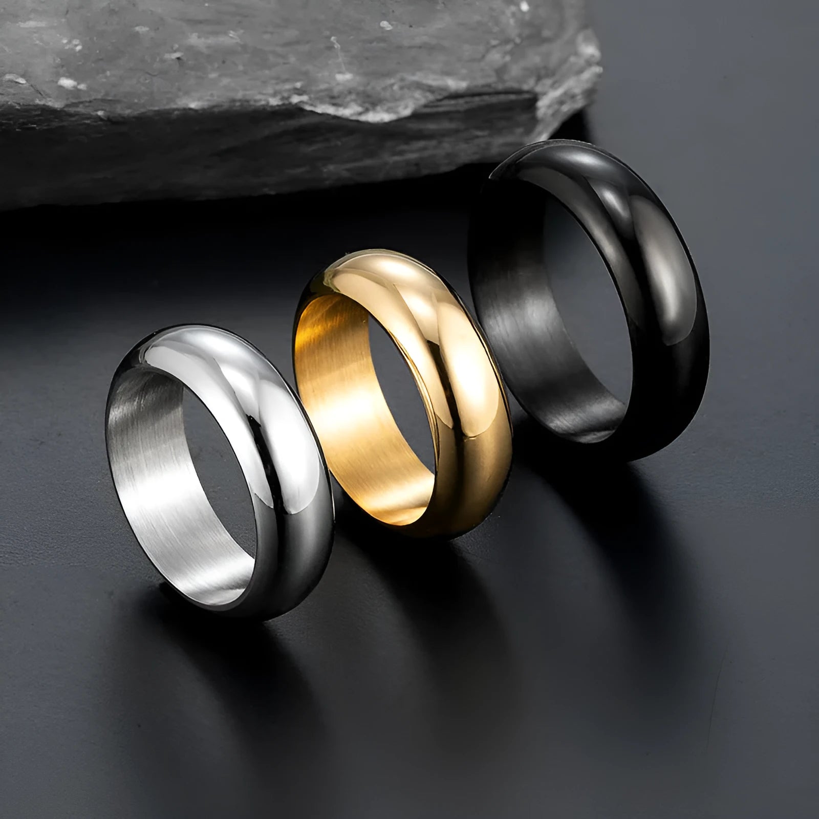 Glossy electroplated titanium steel ring in gold colour on a plain background.