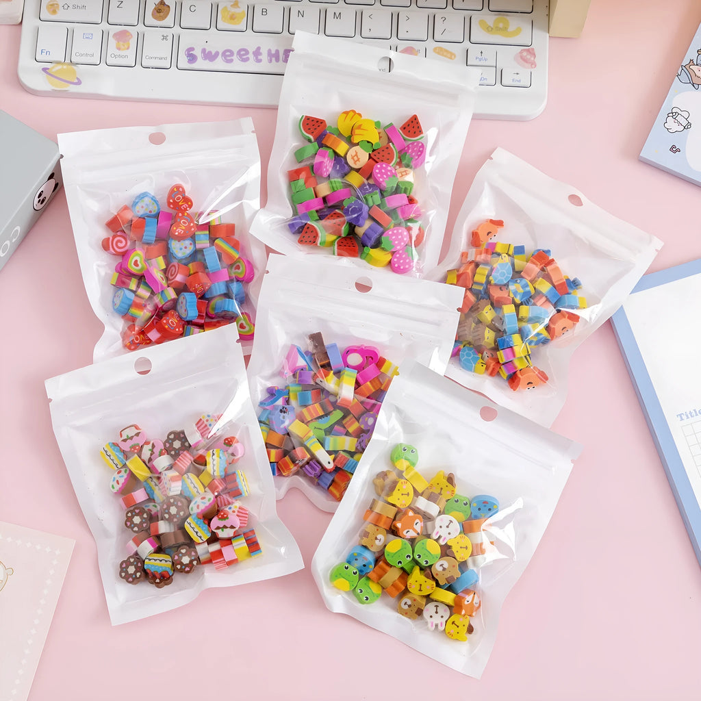 Assortment of colourful TPR cartoon mini erasers showing fruit, animal, and cake designs from a 50-piece pack.