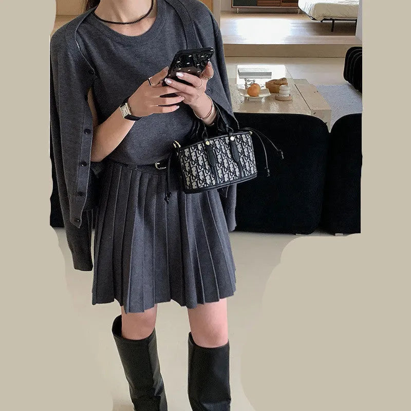 Women's grey knitted national style two-piece set with cardigan, pleated vest skirt, and belt.