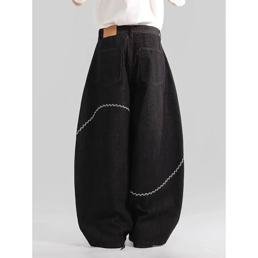Black straight-leg denim trousers with micro-elastic fabric and mid-waist zip fly