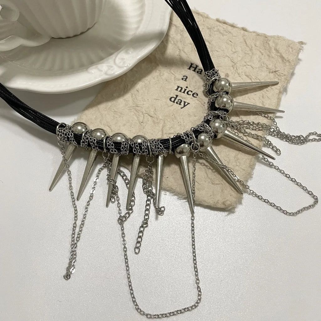 Leather necklace with electroplated rivets, round beads, and a tassel in a winding casual design