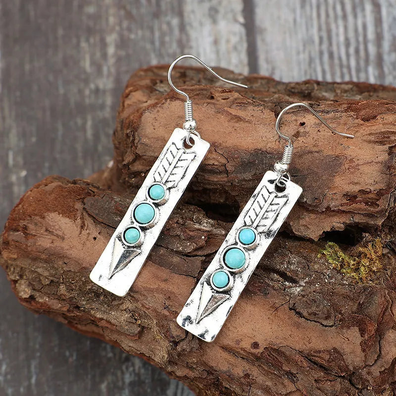 Long geometric silver earrings with turquoise stone accents and retro design