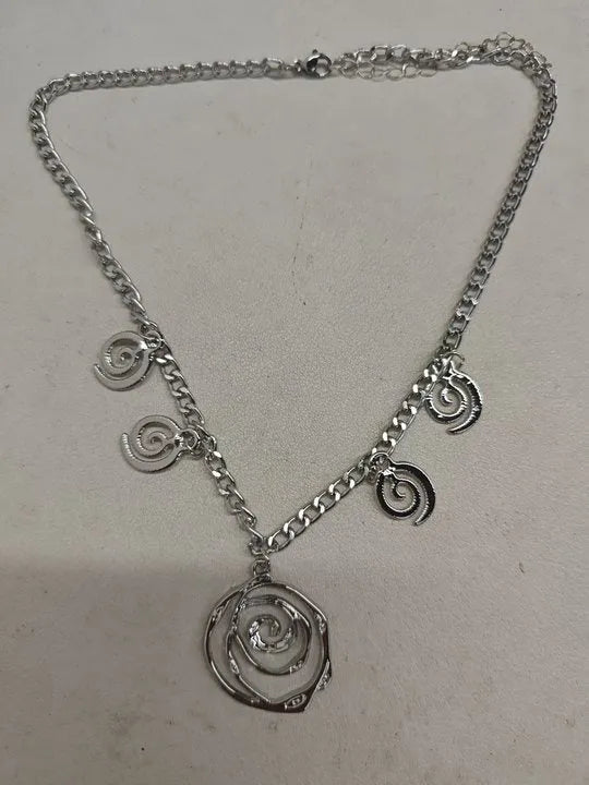 Gold tone donut spiral necklace, bracelet, and earrings set on a white background.