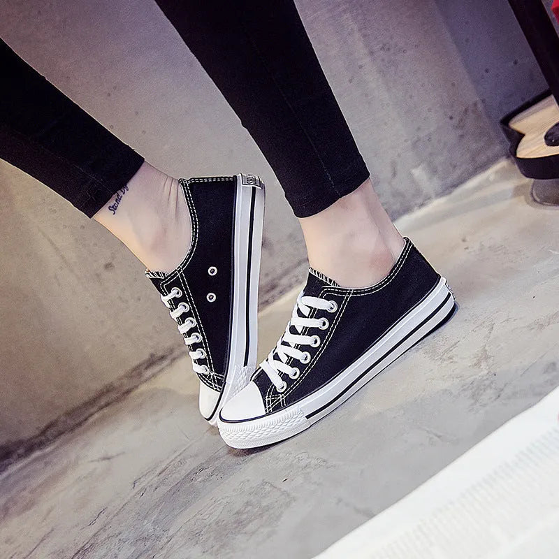 Women's solid colour canvas casual trainers in All Black, shown from the side on a white background.