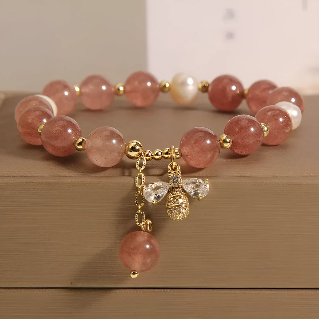 Women's bracelet with three freshwater pearls, a pink strawberry quartz charm, and sparkling zircon stones on an alloy chain.
