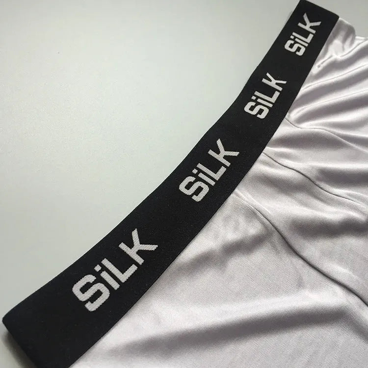 Men's loose fit silk shorts in navy blue, shown in a casual setting