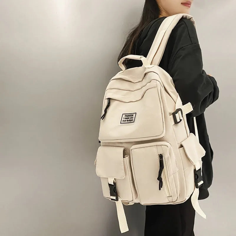 Black and white soft nylon student backpack with laptop compartment and external pockets.