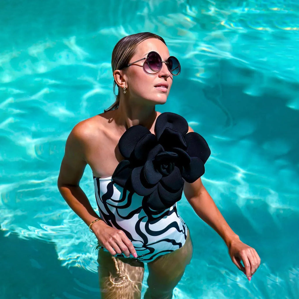 Women's solid colour one-piece swimsuit with three-dimensional flower design.
