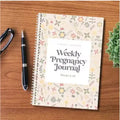 A5 pregnancy diary notebook open to weekly pregnancy tracking pages