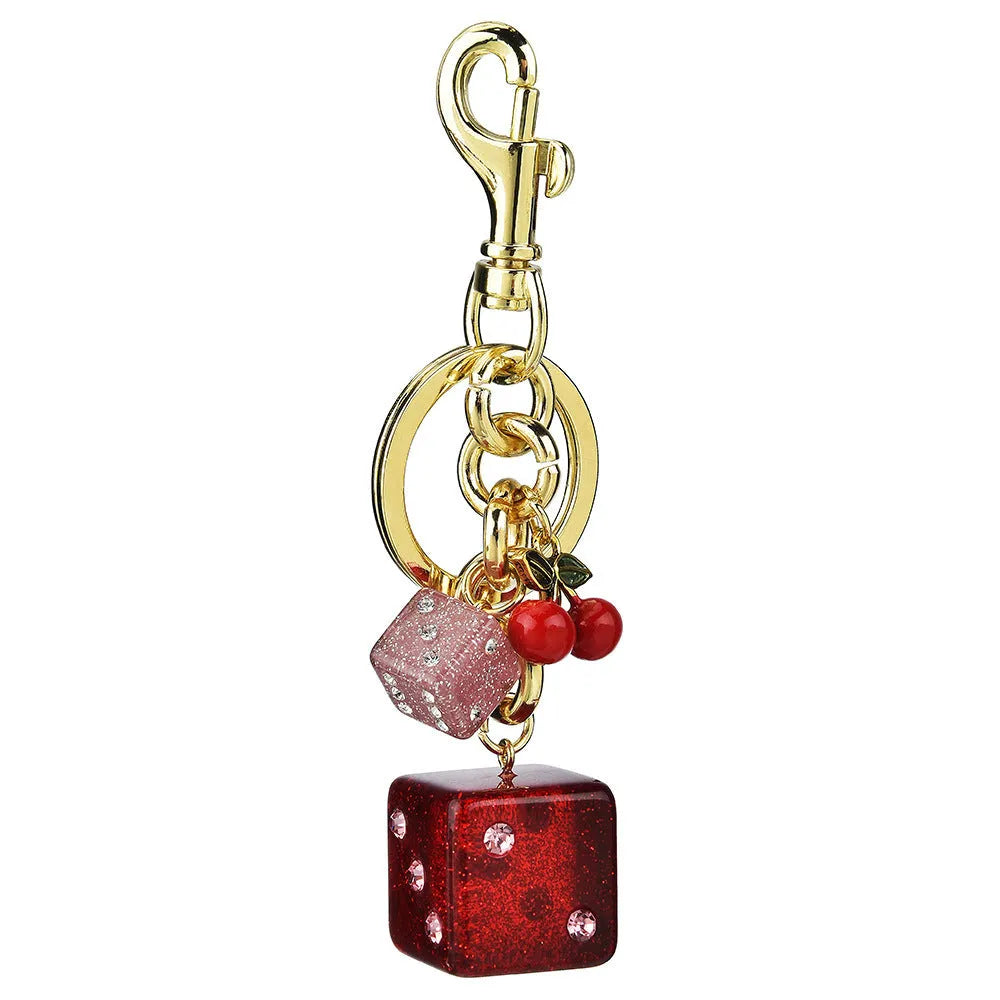 Close-up of a square metal keychain pendant with a two-tone red cherry dice pattern.
