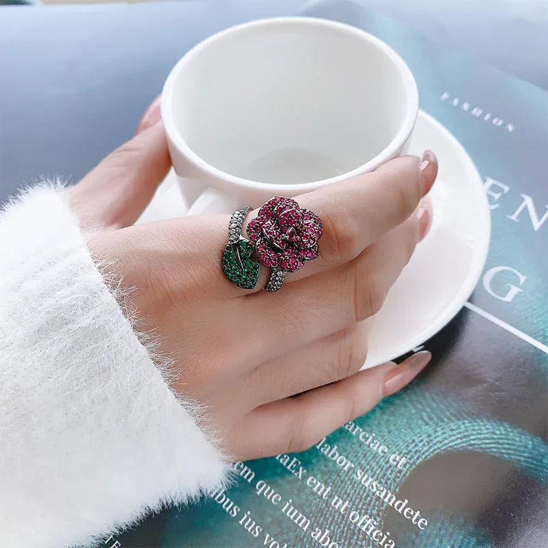 Gold-plated women's ring with a geometric black gold flower design and simulated red corundum detail.