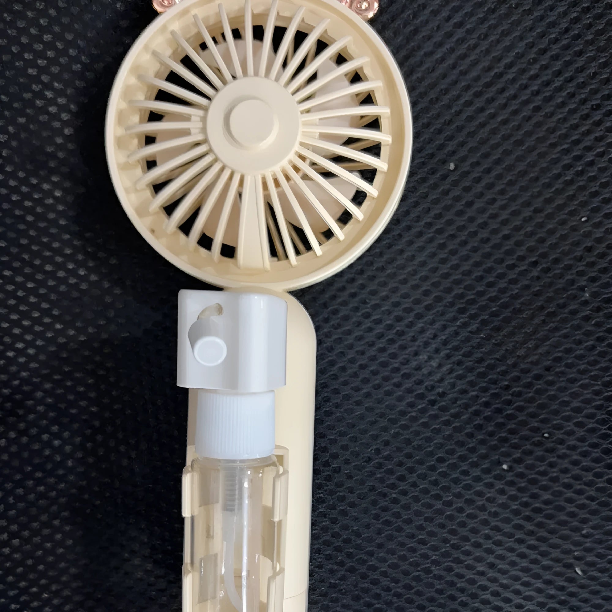 Compact plastic USB-powered nozzle fan in apricot, blue, green, orange or pink colour on a desk.